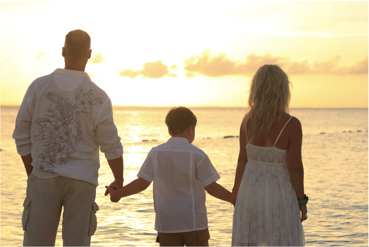Family holding hands at sunset on a Turks and Caicos beach