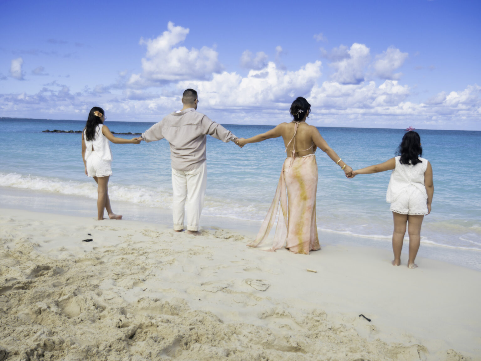 Family walking together at sunset on the beach in Turks and Caicos