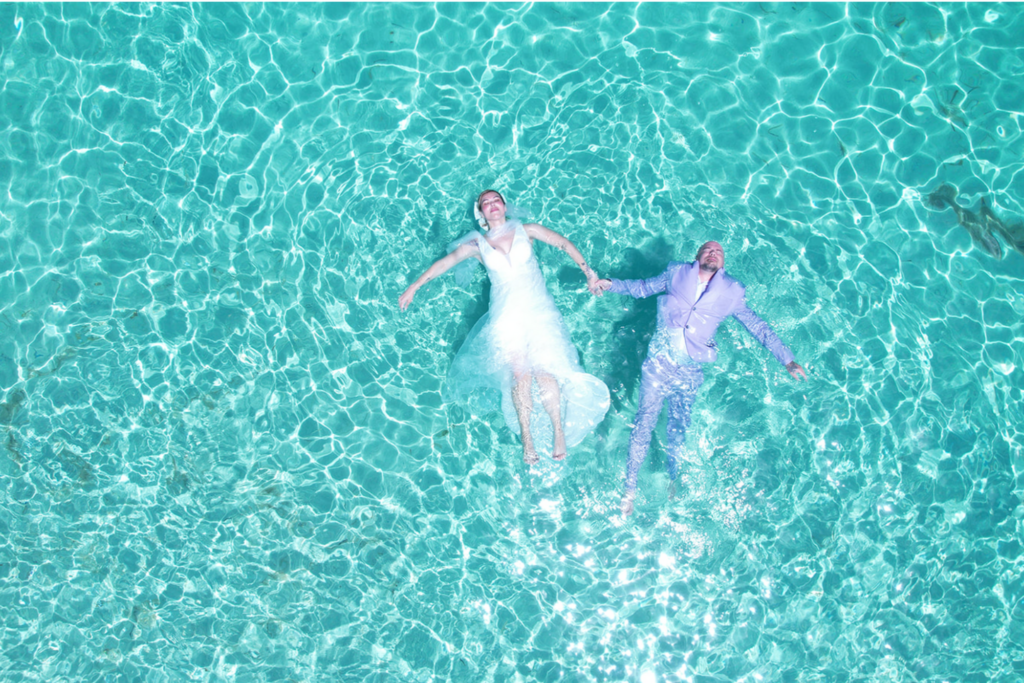 Home Aerial drone photo of a couple floating in the turquoise water of Turks and Caicos